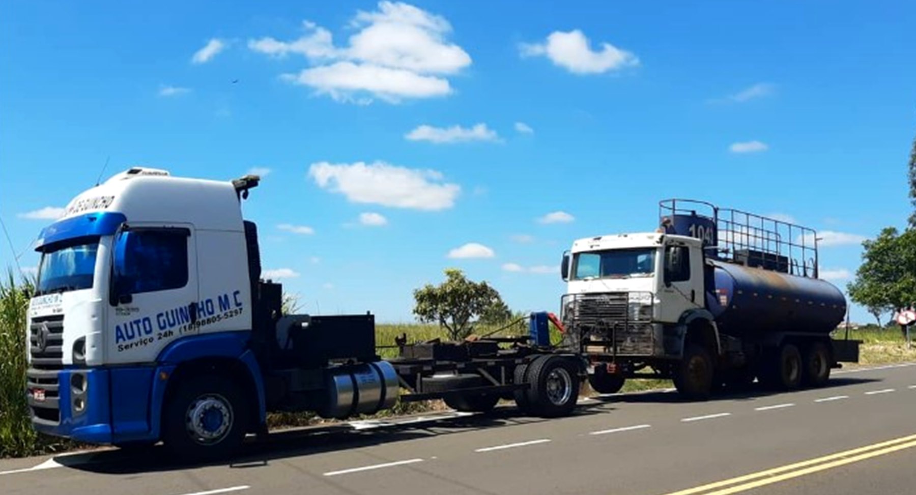Caminhão guincho da MC Auto Guincho rebocando um caminhão-tanque em uma estrada da região de Araçatuba